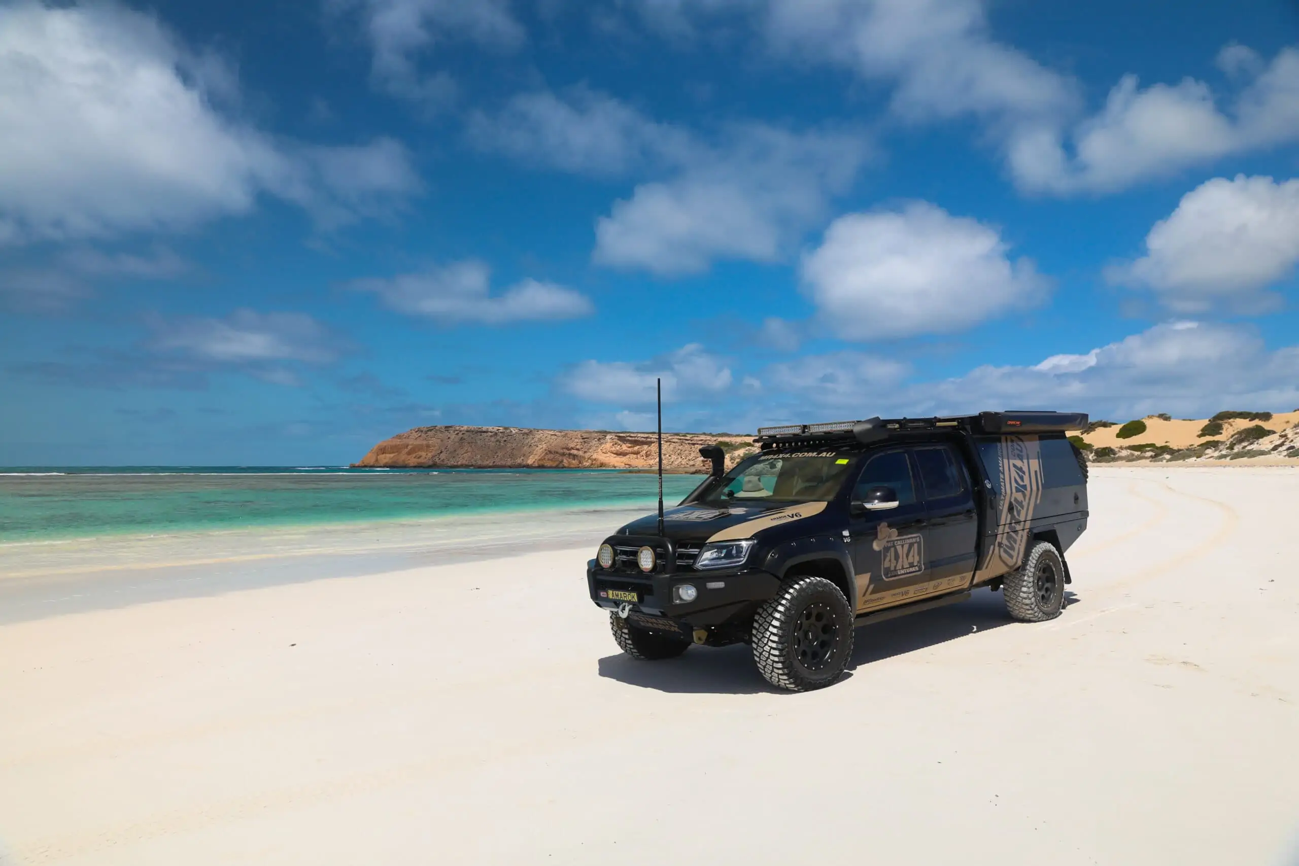 VW Amarok on a beach with Camp King Canopy & Tray